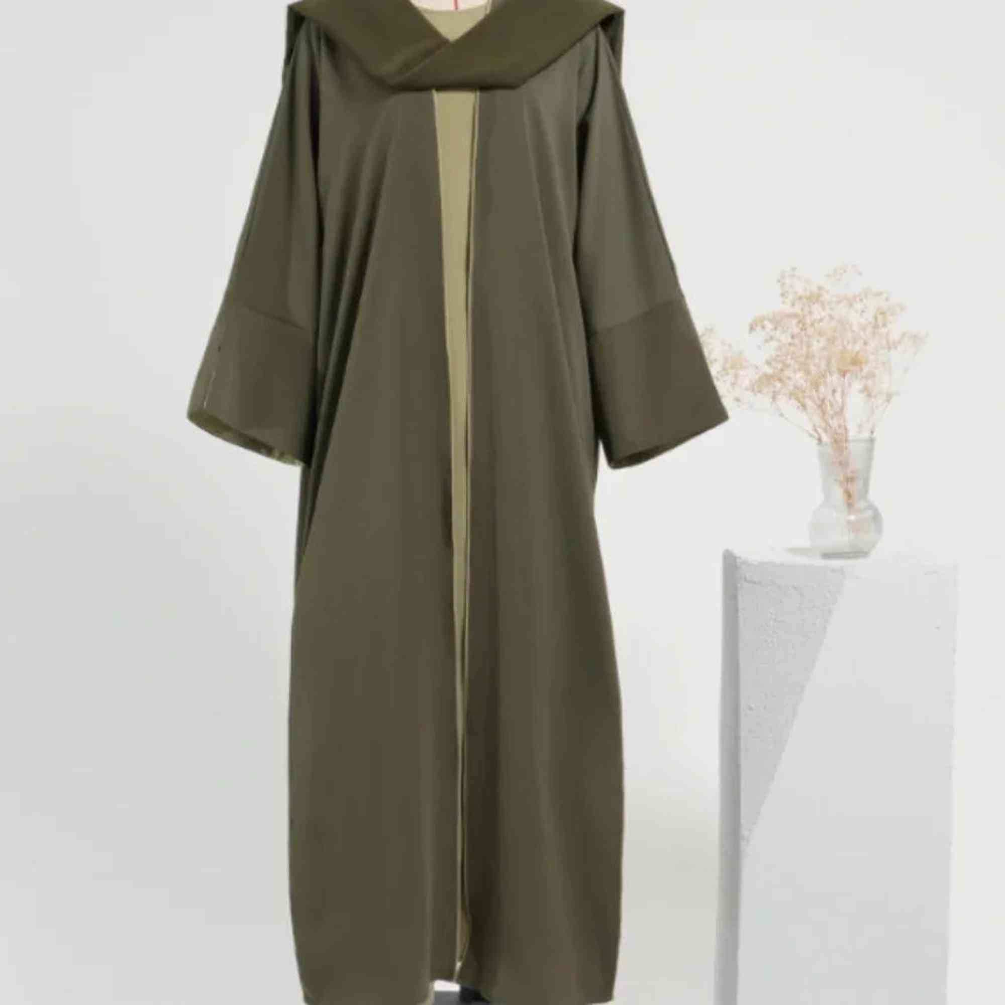 Olive green abaya modest dress on mannequin, minimalist setting, Zahra's Best fashion
