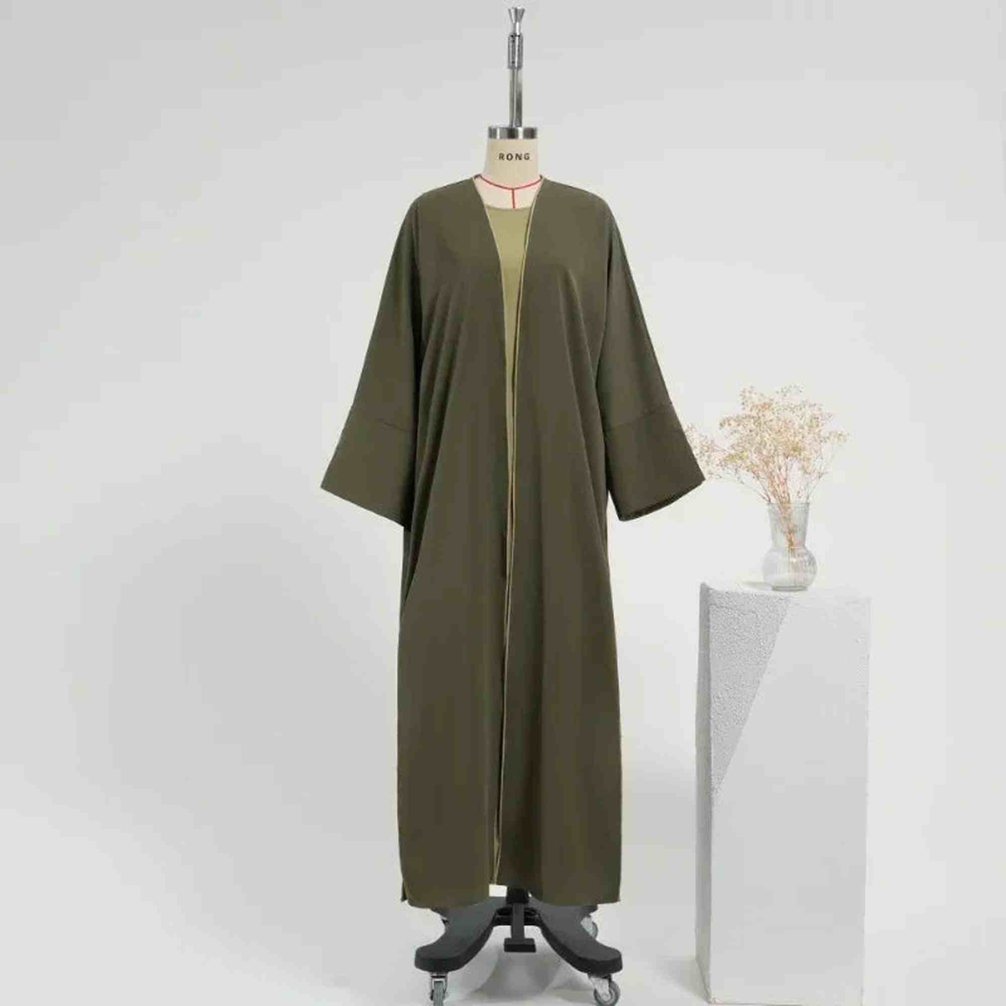 Olive green modest abaya on mannequin, featured by ZAHRA'S BEST, minimalist studio setup