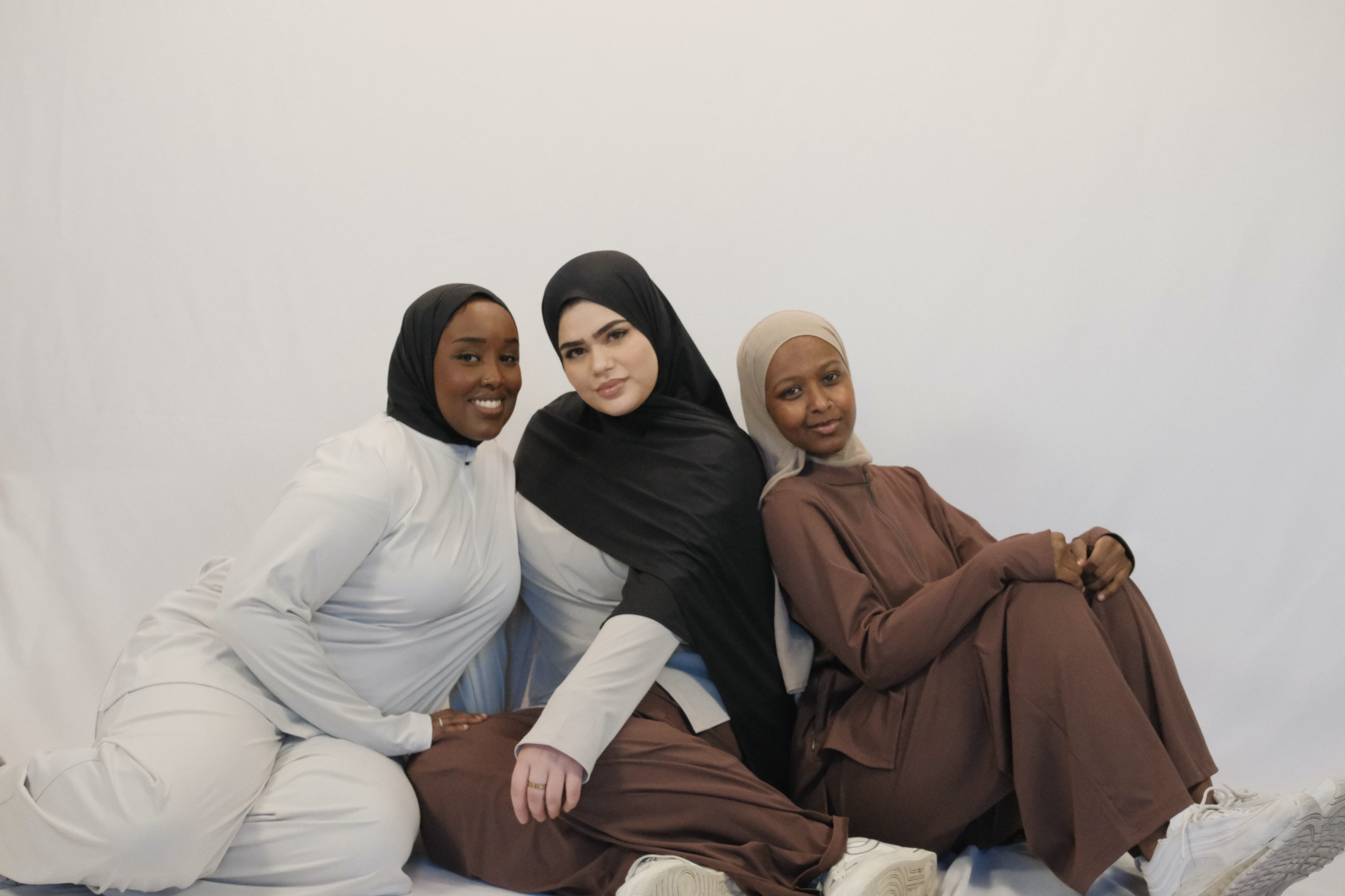 Three women wearing  Mira Active Sets with hijabs in cocoa, cloud and sand veil sitting together - Mira AirFlex Set  - ZAHRA'S BEST