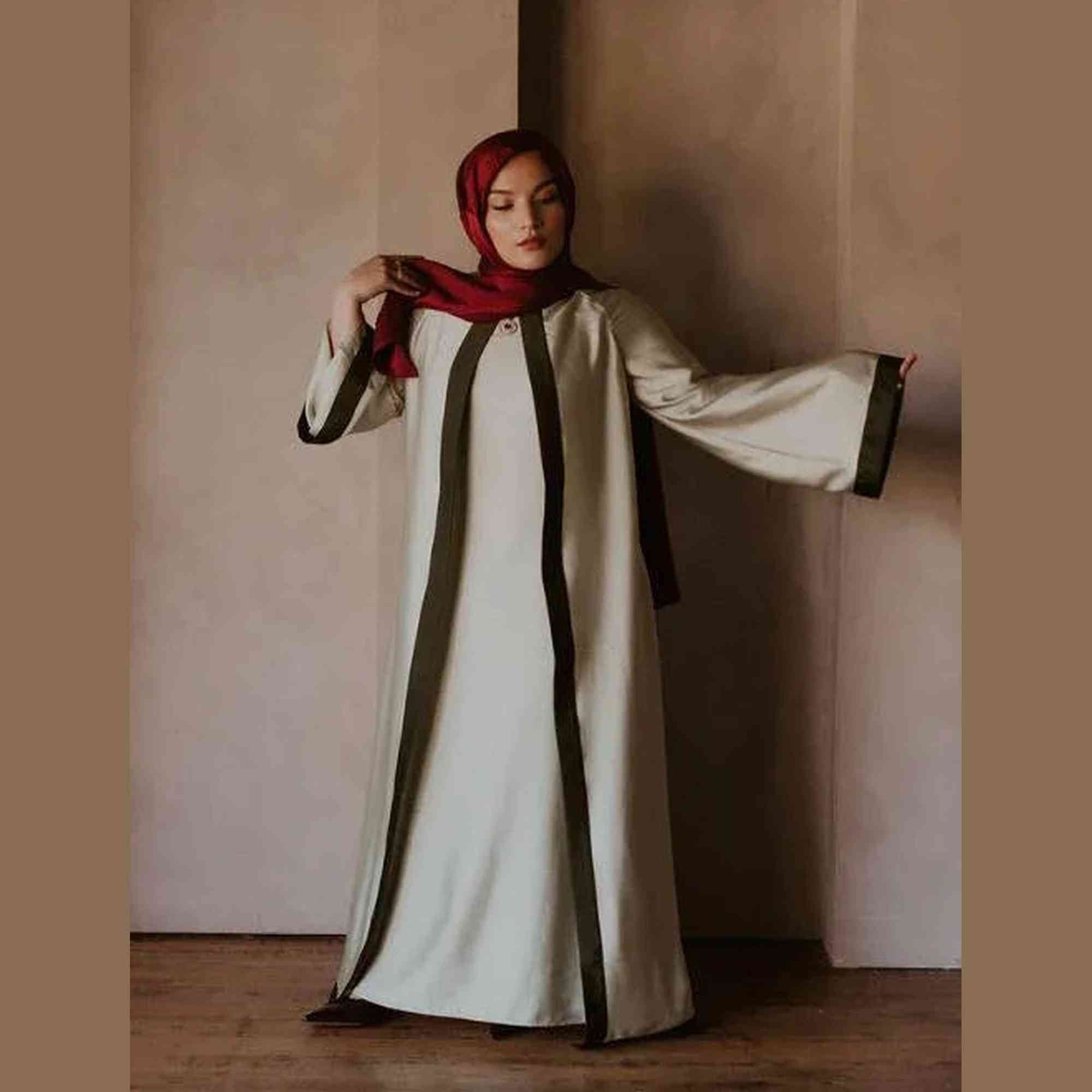 Woman in elegant modest abaya with green accents and red hijab, ZAHRA'S BEST fashion